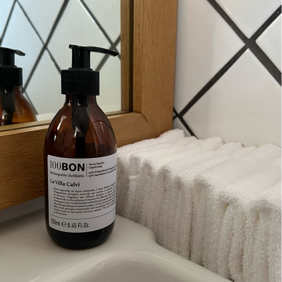 Savon liquide naturel en flacon La Villa Calvi sur lavabo et serviettes